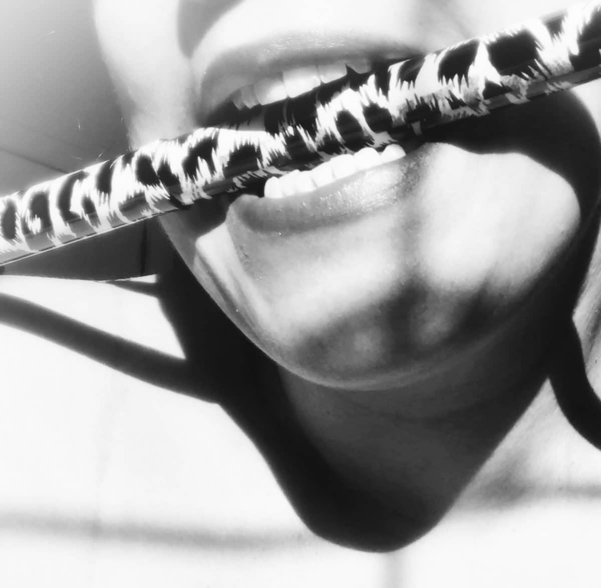 B&W photo of me holding zebra-print walking stick between my teeth