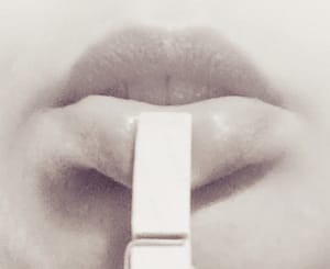 Rose-tinted monocolour photo of my lips with a clothespeg attached to the lower one